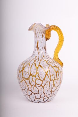 un vase blanc et doré avec une anse jaune