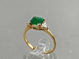 a close up of a ring with a green stone on top of it