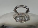 a silver plate with a silver lid on a table