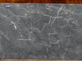 grey marble slab on a wooden table with a brown chair in the background