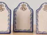 three blue and white plates with monograms on them