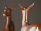 two statues of a deer that are standing next to each other