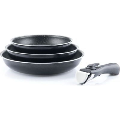 deux casseroles noires et une spatule posées sur une surface blanche