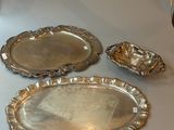 three silver trays sitting on a table next to each other