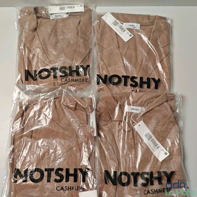 four t - shirts are wrapped in plastic bags on a table