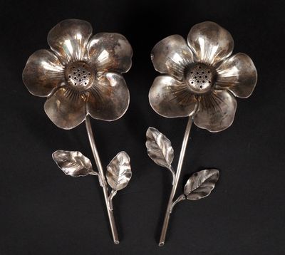 paire de fleurs plaquées argent avec des feuilles sur des tiges