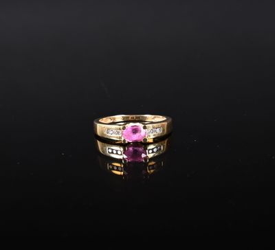 une bague sertie d'un saphir rose et de diamants, posée sur un fond noir