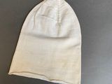 a close up of a white hat on a gray surface