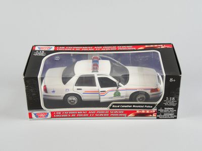 une voiture de police miniature dans une boîte, posée sur une surface blanche