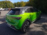 a green car that is parked in a parking lot