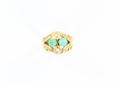 un gros plan d'une bague en or sertie de deux pierres vertes