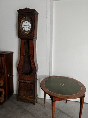 une horloge de parquet posée à côté d'une petite table dans une pièce