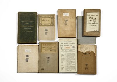 several old books sitting on top of each other on a white surface