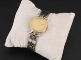 une photo d'une montre-bracelet posée sur un oreiller, sur un fond noir