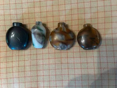 trois bouteilles en verre posées sur une table recouverte d'une nappe à carreaux