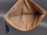 a brown bag with a tassel hanging from it ' s side