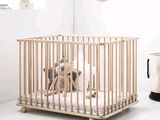 un petit berceau en bois avec une peluche à l'intérieur