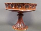 a large brown bowl on a pedestal on a table