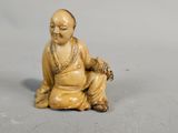 a small figurine of a man sitting on the ground