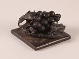 a statue of a bird sitting on a pile of grapes