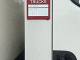 un camion blanc avec une enseigne rouge sur le côté