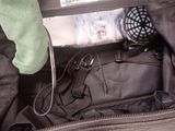 a black bag with a fan and a bottle of water inside of it
