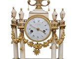 a white and gold clock sitting on top of a table