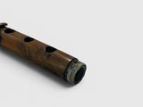a close up of a wooden flute on a white surface