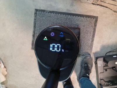 une personne debout près d'un mur sur lequel est accrochée une horloge numérique