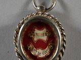 une photo d'un pendentif sur lequel figure le portrait d'une femme