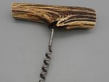 a close up of a bottle opener with a wooden handle