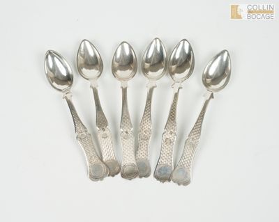 six cuillères en argent sont alignées sur une surface blanche