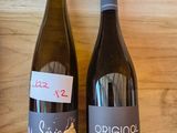 two bottles of wine sitting on a wooden shelf