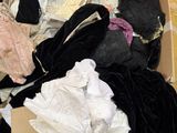 une boîte remplie de vêtements et de chaussures posée par terre