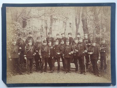 une vieille photo montrant un groupe d'hommes en uniforme posant pour une photo