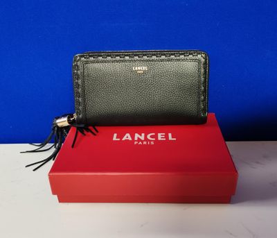 a black and green wallet sitting on top of a red box