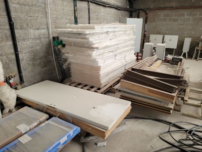 une pièce où il y a beaucoup de cartons et de palettes par terre