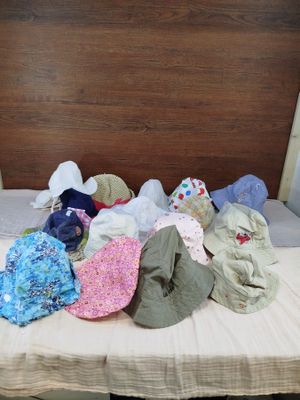 a bed with many hats on it in a room