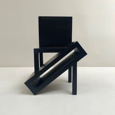 une image représentant une chaise noire posée sur un sol blanc