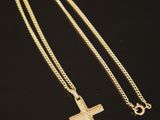 un collier avec une croix en or sur fond noir