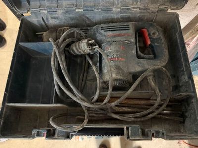 une boîte à outils contenant une perceuse et un cordon