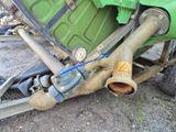un gros plan d'un tracteur vert auquel est raccordé un tuyau