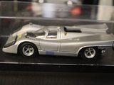 a silver toy car in a clear box on a table