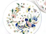 two plates with colorful designs on them on a table