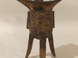 une vieille statue en bronze représentant un homme coiffé d'un chapeau