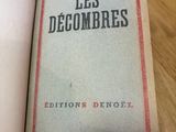 un livre ouvert posé sur une table en bois, à côté d'une tasse de café