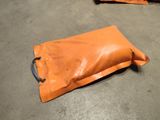 two bags of orange plastic sitting on the floor