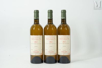 trois bouteilles de vin posées les unes à côté des autres sur une surface blanche