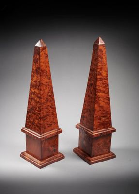 a pair of wooden obelis on stands on a grey background