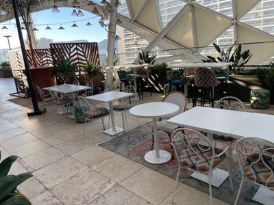 des tables et des chaises sur le toit d'un immeuble